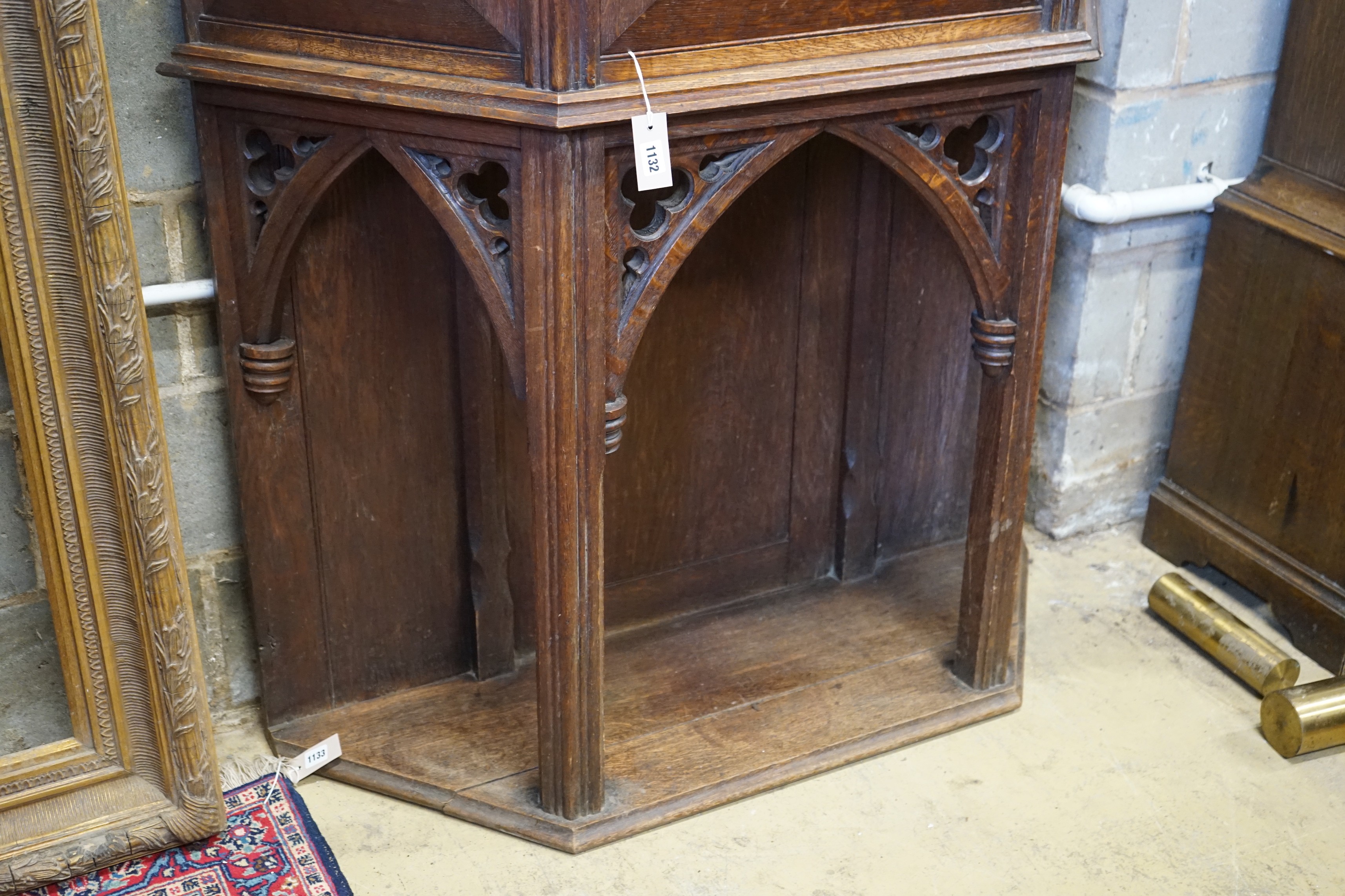 An early 20th century Gothic style carved oak side cabinet, width 118cm, depth 36cm, height 176cm
